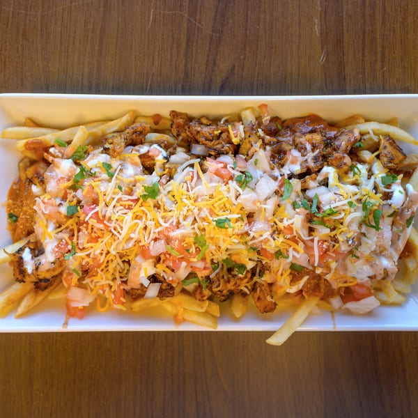 Loaded french fries topped with chicken, shredded cheese, pico de gallo, and creamy sauces.